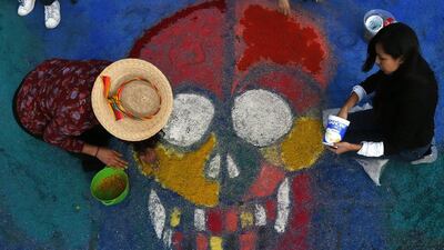Residents create a sawdust representation of a skull during Day of the Dead festivities in Mexico City, on October 27, 2016. The holiday honours the dead, as friends and families gather in cemeteries to decorate their loved ones’ graves and hold vigils through the night on November 1 and 2. Marco Ugarte / Associated Press