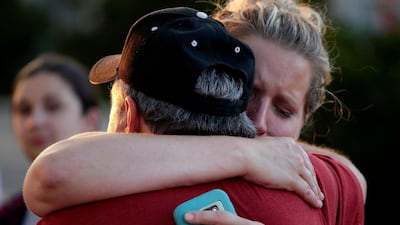 Rachel Riutzel hugs Russ McKay as he looks at a makeshift memorial for his friends before a candlelight vigil in the parking lot of Ride the Ducks Friday, July 20, 2018 in Branson, Mo. AP