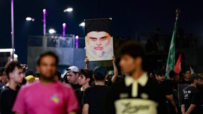 Supporters of Mr Al Sadr carry his portrait as they protest near Baghdad's Green Zone. AFP