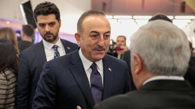 Mevlut Cavusoglu, Turkey's foreign affairs minister, speaks to an attendee between sessions on the opening day of the World Economic Forum (WEF) in Davos, Switzerland, on Tuesday, January 21, 2020. Jason Alden/Bloomberg