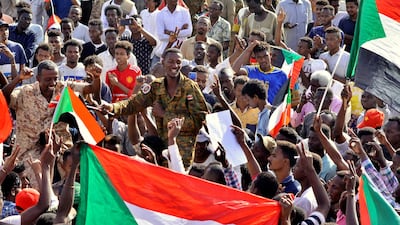 Sudanese military officer joins demonstrators as they celebrate Defence Minister Awad Ibn Auf stepping down as head of the country's transitional ruling military council. Reuters