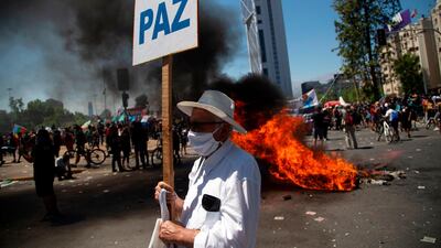An elderly man holds a placard reading "Peace" in Santiago. AFP