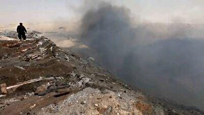 A bulldozer operator looks at the landfill blaze at Jebel Ali.