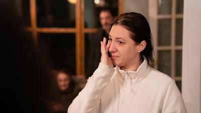 Valeriia Starkova wipes a tear from her eye as she is reunited with her family in Caldecote.