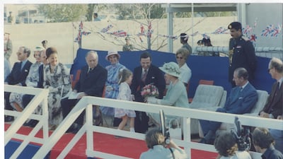 The queen, in a mint green outfit with matching hat, is presented with a bouquet by four-year-old Victoria Evans, the youngest female pupil, in 1979.