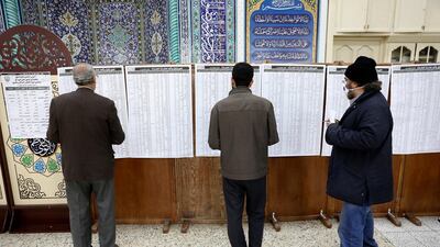 Voters check the lists of candidates in the parliamentary elections at a polling station in Tehran, Iran. AP