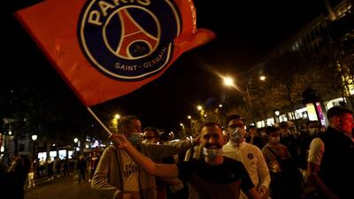 Paris Saint-Germain supporters wave a PSG flag on the Champs-Elysees in Paris. AFP