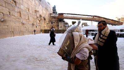 An ultra-Orthodox Jewish man carries a Torah scroll at the Western Wall in Jerusalem. Reuters