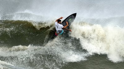 Italo Ferreira preforms on the wave during the gold medal heat in the men's surfing competition.