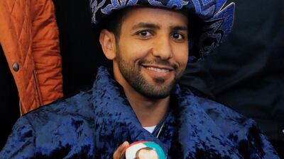 Hazza Al Mansouri poses for a photo wearing a Kazakh national hat and holding a Matryoshka, Russian traditional wooden doll depicting him. Reuters