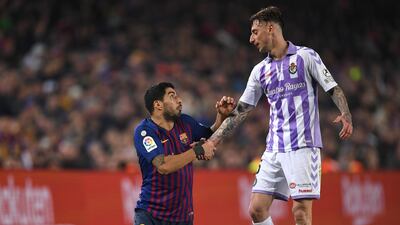 Real Valladolid's Fernando Calero helps Barcelona's Luis Suarez to his feet. Getty Images