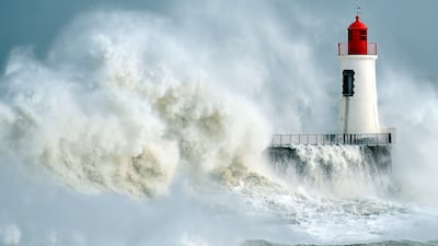 (FILES) This file photo taken on February 9, 2016 shows waves breaking against a pier and a lighthouse in Les Sables-d'Olonne, western France. Deaths due to weather-related disasters in Europe could increase fifty-fold from an estimated 3,000 per year recently to 152,000 by century's end, mainly due to climate change, researchers warned on August 5, 2017. / AFP PHOTO / LOIC VENANCE