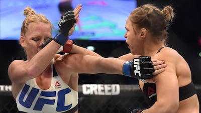 Ronda Rousey of the US (R) lands a punch on the face of compatriot Holly Holm during the UFC title fight in Melbourne on November 15, 2015. AFP PHOTO/Paul CROCK