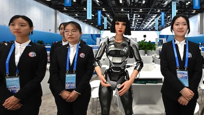 Volunteers stand next to a humanoid robot named Xiao Qi, developed by Ex-Robots, before the Forum on China-Africa Co-operation. AFP