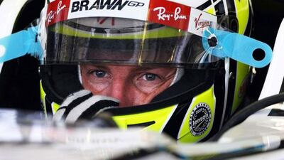 Above, the F1 world champion Jenson Button in the cockpit of his Brawn GP car as he prepares for his first practice round yesterday.