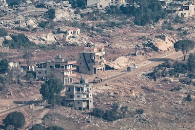 An Israeli flag is draped over a destroyed house in the southern Lebanese village of Taybeh, as seen from northern Israel. EPA