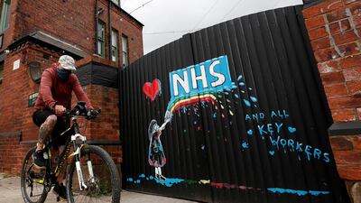 A cyclist rides past a mural in tribute to the NHS painted by artist Rachel List in Pontefract, Britain. Reuters