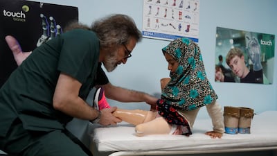 Dr Mehmet Zeki Culcu adjusts Maya's new limbs. Reuters