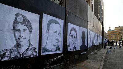 Activists hang portraits of the victims of the August 4 Beirut port explosion on a wall in the Lebanese capital. Artist Brady Black, in partnership with the Art of Change organisation, drew more than 200 caricatures of the victims. EPA