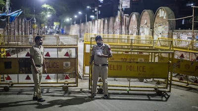 Indian policemen stand guard at a deserted commercial hub as they enforce a lockdown, in New Delhi, India. Getty Images