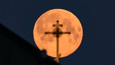 The church cross is silhouetted by the pink supermoon in downtown Moscow, Russia. AFP