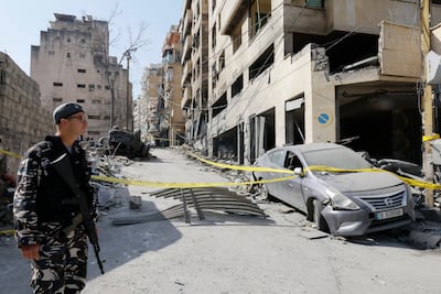A Lebanese policeman stands guard next to a damaged building targeted by Israeli air strikes in Beirut's Bashura neighbourhood. EPA