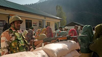 Voters queue to cast their ballots at a polling station in Ganderbal. AFP