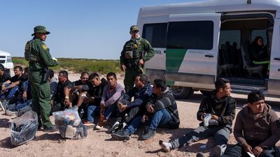 A group of migrants wait to be processed by US authorities after being apprehended trying to cross the border. Reuters