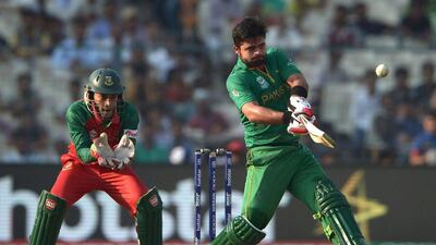 Pakistan’s Ahmad Shahzad, right, plays a shot as Bangladesh’s wicketkeeper Mushfiqur Rahim looks on. (AFP / Dibyangshu SARKAR)