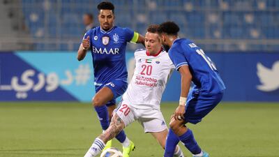 Sharjah midfielder Bernard is marked by Hilal defender Abdulrahman al-Obaid.