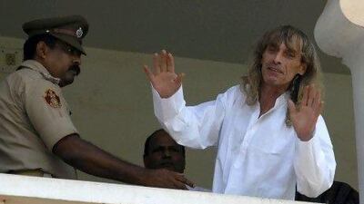 Paolo Bosusco, an Italian tour guide who was taken hostage by Maoist rebels, waves from a balcony of a guesthouse after being freed by rebels in the eastern Indian city of Bhubaneswar.