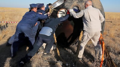 Specialists turn a Russian Soyuz MS-12 space capsule after the landing near the town of Zhezkazgan, Kazakhstan. Reuters