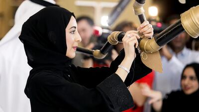 Shamma Al Mazrui, Minister of State for Youth Affairs and head of the Youth Council, places her pledge to help combat climate change on a tree made out of recycled material. She was attending a Youth Circle meeting in Sharjah. Reem Mohammed / The National