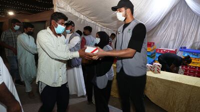 Members of the Sharjah Charity International distributing food parcels to labourers.