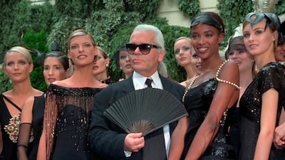 With his famous fan in hand, Lagerfeld salutes the audience along with Linda Evangelista and Naomi Campbell for Chanel's 1996-97 autumn / winter haute couture show. AP