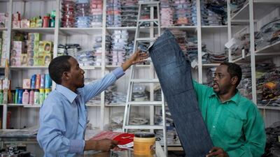 A shopkeeper serves a customer in the Somali capital Mogadishu, where commerce is slowly returning to normal. (Stuart Price / EPA)