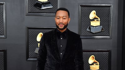 John Legend, wearing a black velvet suit. AFP