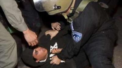 Israeli border policemen detain a settler during clashes outside a disputed house in the flashpoint West Bank city of Hebron.