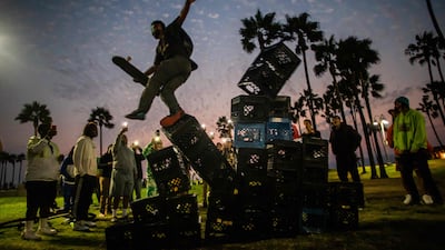 A man falls down of a pyramid of milk crates while he participates of the Milk Crate Challenge in Venice, California. AFP