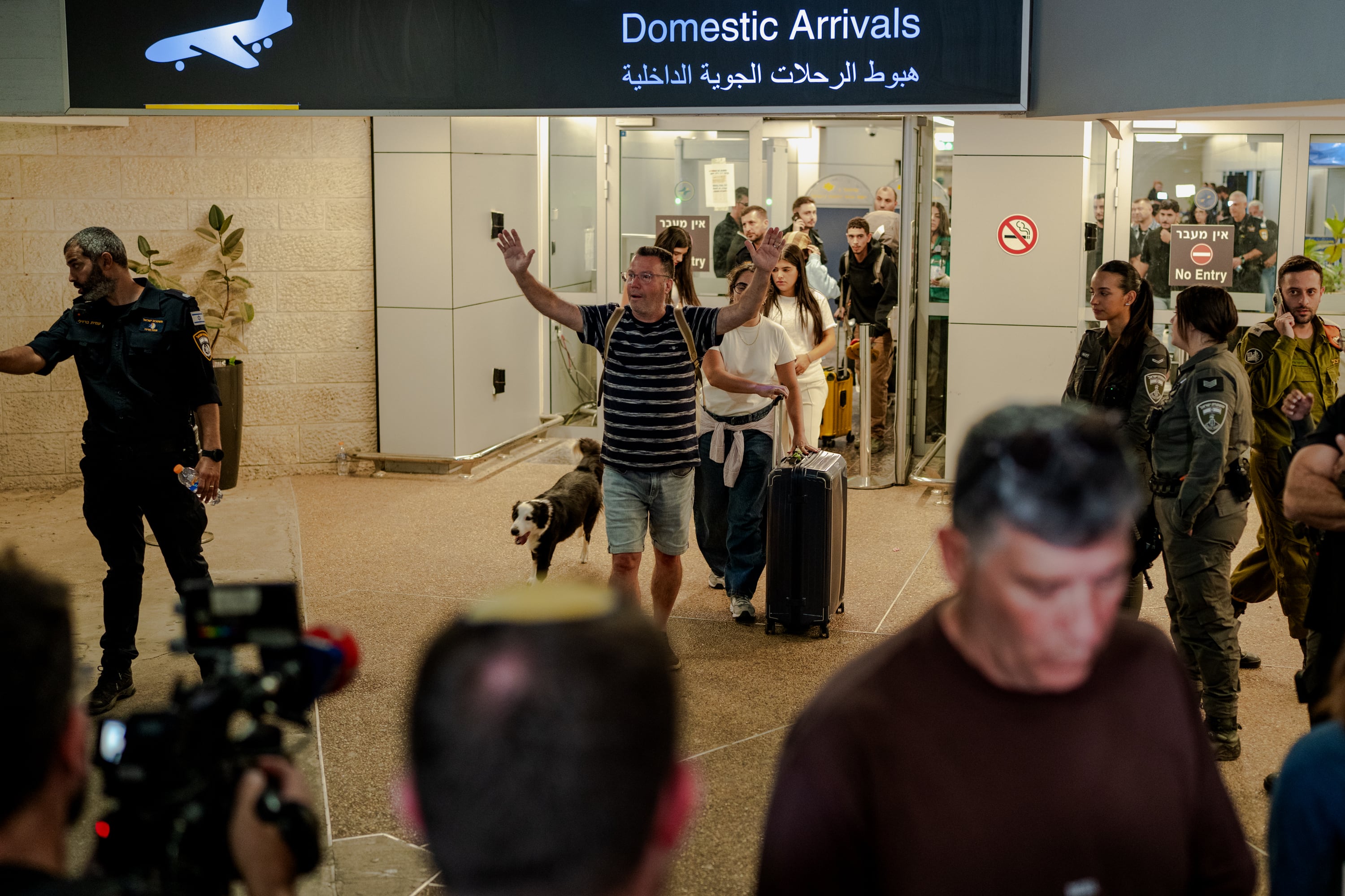 A passenger exits through the domestic arrivals doors with his dog and his luggage at Ben Gurion Airport. Getty Images