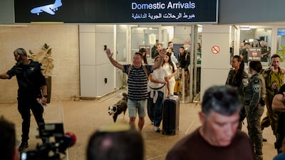 A passenger exits through the domestic arrivals doors with his dog and his luggage at Ben Gurion Airport. Getty Images