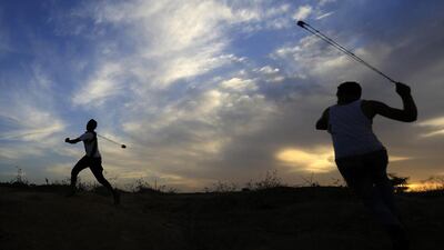 Palestinian protesters use slingshots to throw stones towards Israeli soldiers during clashes in Gaza. (Mohammed Abed / AFP)
