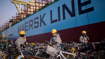 Workers take a break outside an under-construction Maersk triple-E class container ship. Ed Jones / AFP