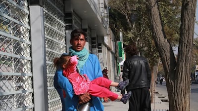 A man carries his frightened child away from the scene of the deadly explosions. EPA