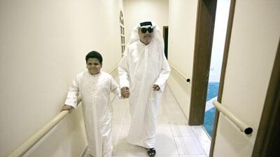 Mahmoud Najib and his teacher, Ahmed Mukhtar, walk down hallway at the EAB in Sharjah.