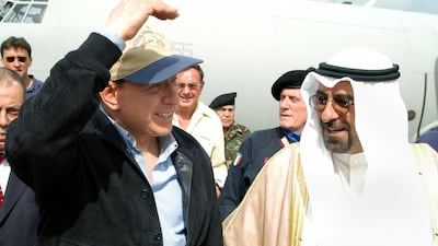 Mr Berlusconi, left, is greeted during a stopover at Kuwait airport in April 2004 after visiting Italian troops at their base in the southern Iraqi city of Nasiriyah. AFP