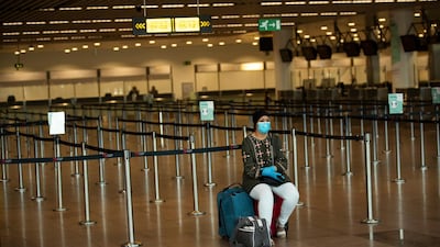 A passenger, wearing a face mask to protect against the spread of coronavirus, sits at the almost empty departures hall at the Zaventem international airport in Brussels. AP.