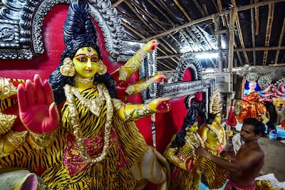 An artisan gives final touches to a clay idol of the Hindu deity Durga at a workshop ahead of Navratri, in Allahabad. AFP