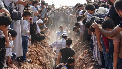 Members of the Syrian civil defence volunteers, also known as the White Helmets, bury their fellow comrades during a funeral in Sarmin, a militant-held town nine kilometres east of Syria's northwestern city of Idlib