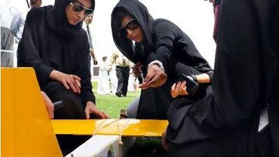 Members of the Royal Queenz team, from Abu Dhabi Women's College, prepare their model, and possibly their careers, for launch at the competition.